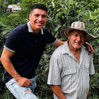 Jaime and his son, Jaime Andrés Casallas, standing next to coffee trees.